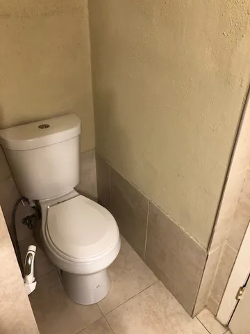 a white toilet sitting next to a shower