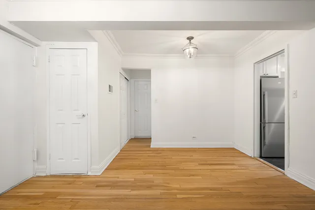 a dining room with wooden floor a chandelier a wooden table and chairs