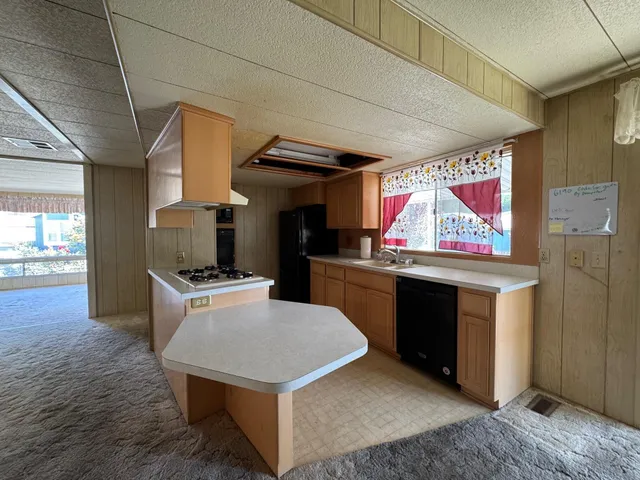 a kitchen with stainless steel appliances a stove a refrigerator a sink and a counter