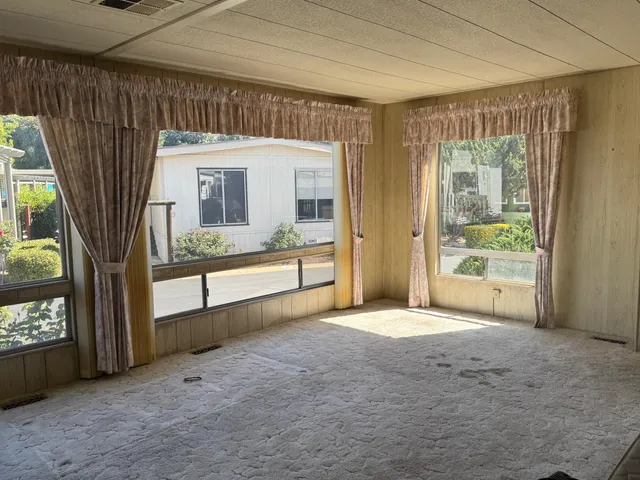 a view of an empty room with a fireplace and a window