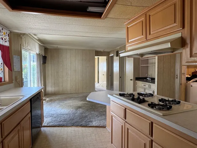 a kitchen with stainless steel appliances granite countertop a sink stove and cabinets