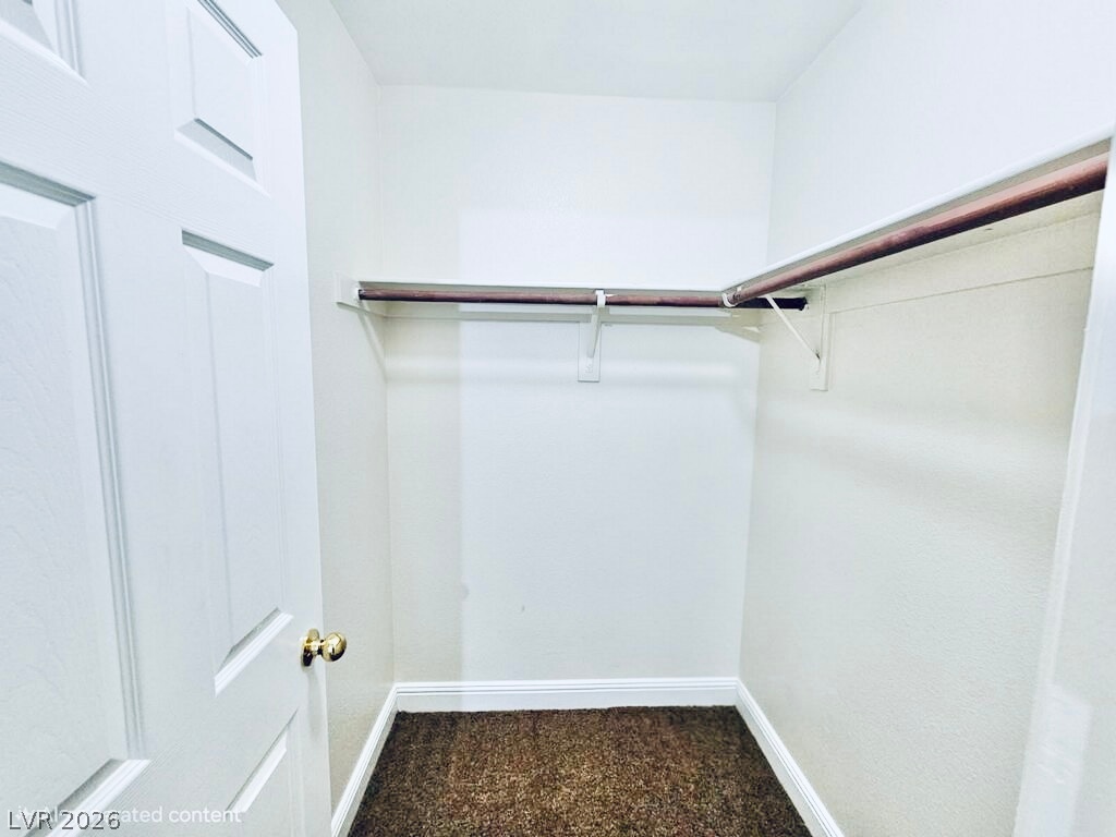 5953 Crumbling Ridge Street Henderson, NV 89011 - Photo 35 of 42 Ample hanging space and carpeted flooring offer organized storage within this walk-in closet.