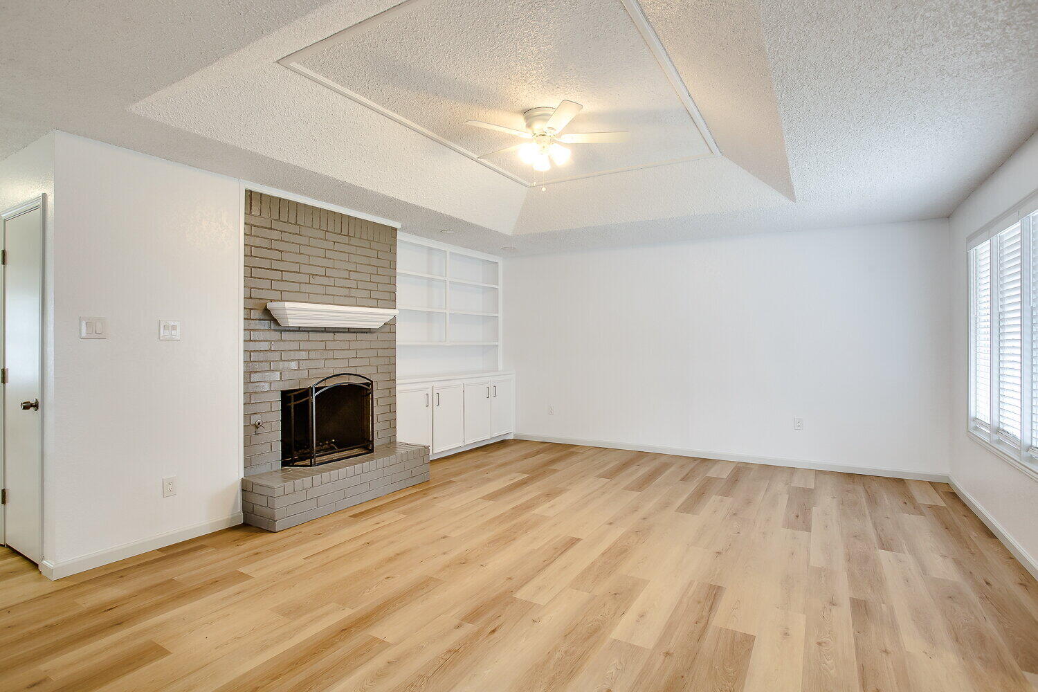 4804 76th Street, Unit A Lubbock, TX 79424 - Photo 13 of 31 a view of empty room with wooden floor and fireplace