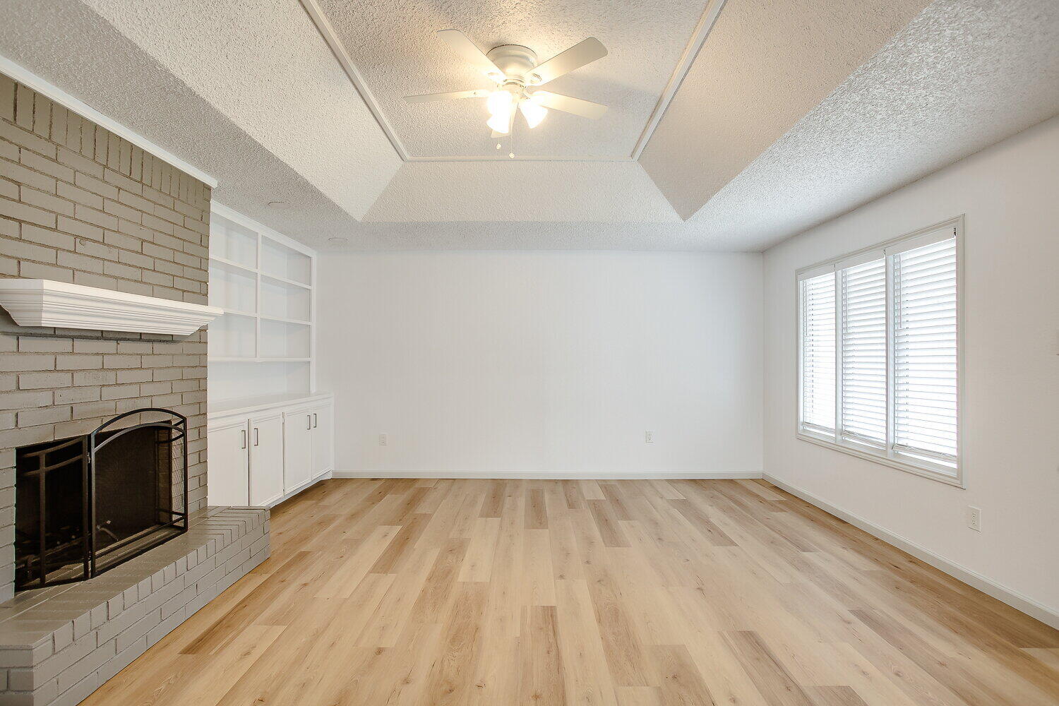 4804 76th Street, Unit A Lubbock, TX 79424 - Photo 14 of 31 wooden floor in an empty room with a fireplace