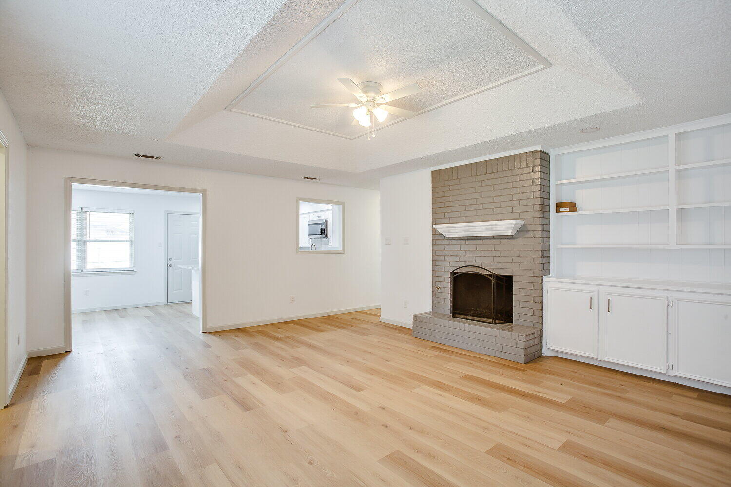 4804 76th Street, Unit A Lubbock, TX 79424 - Photo 15 of 31 a view of an empty room with wooden floor fireplace and a window