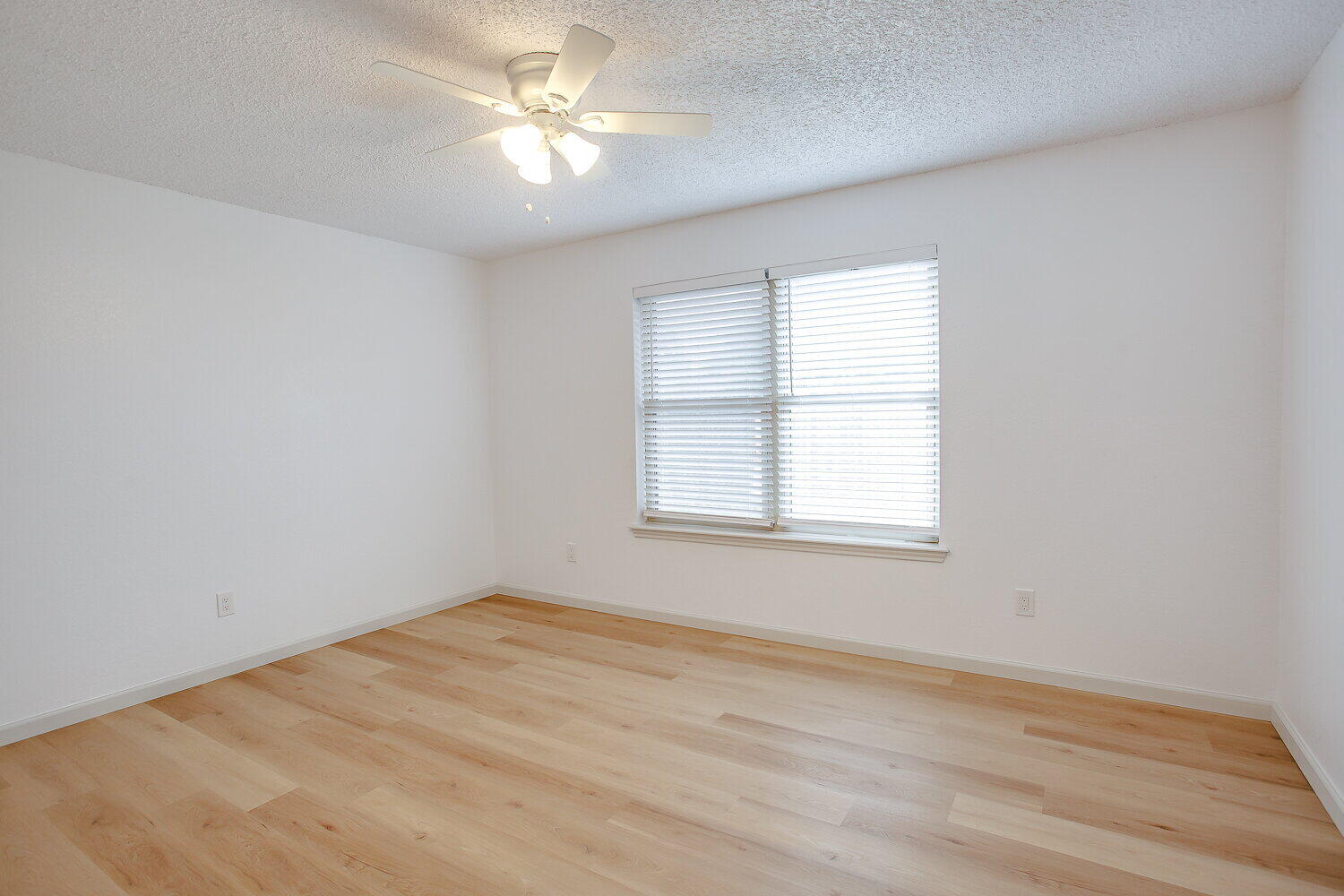 4804 76th Street, Unit A Lubbock, TX 79424 - Photo 19 of 31 an empty room with a window and a fan