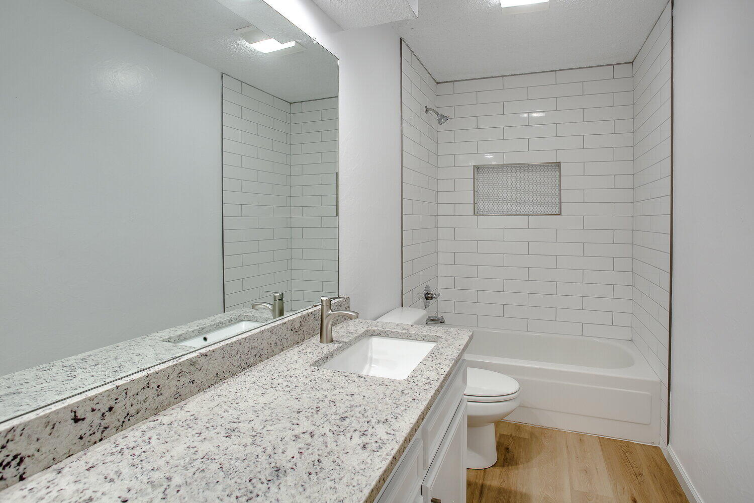 4804 76th Street, Unit A Lubbock, TX 79424 - Photo 20 of 31 a bathroom with a granite countertop sink toilet and shower