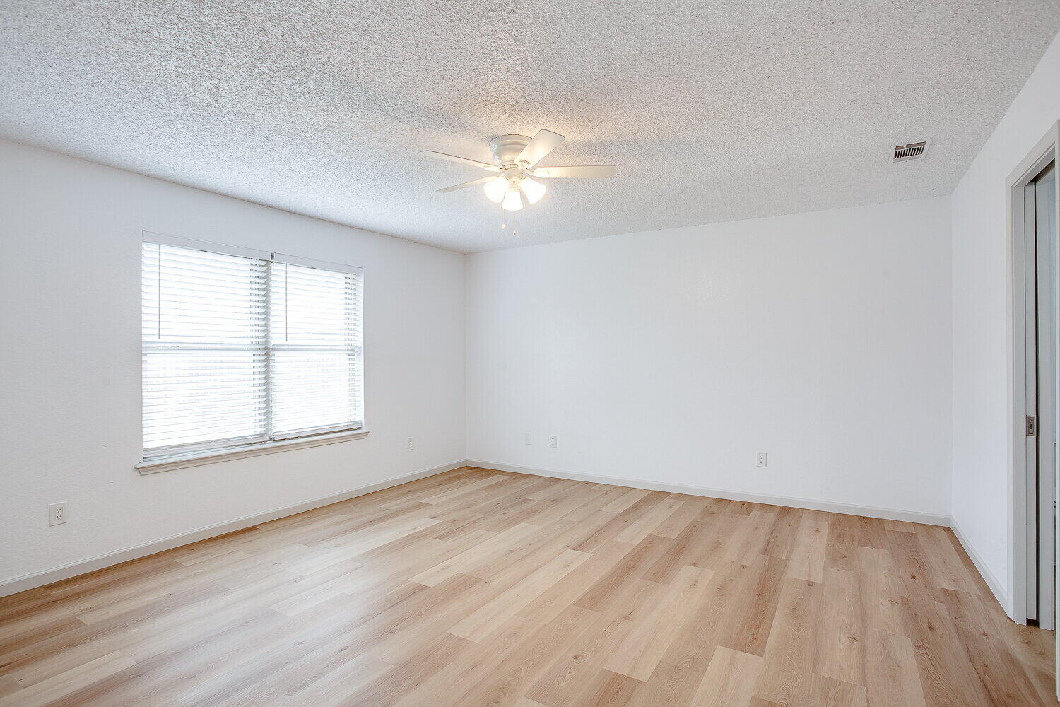 4804 76th Street, Unit A Lubbock, TX 79424 - Photo 21 of 31 an empty room with wooden floor and windows