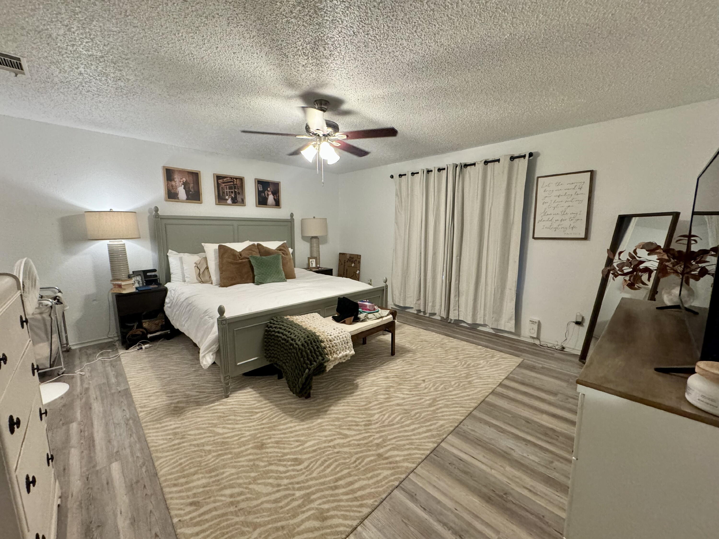 4804 76th Street, Unit A Lubbock, TX 79424 - Photo 29 of 31 a bedroom with a bed and a chandelier