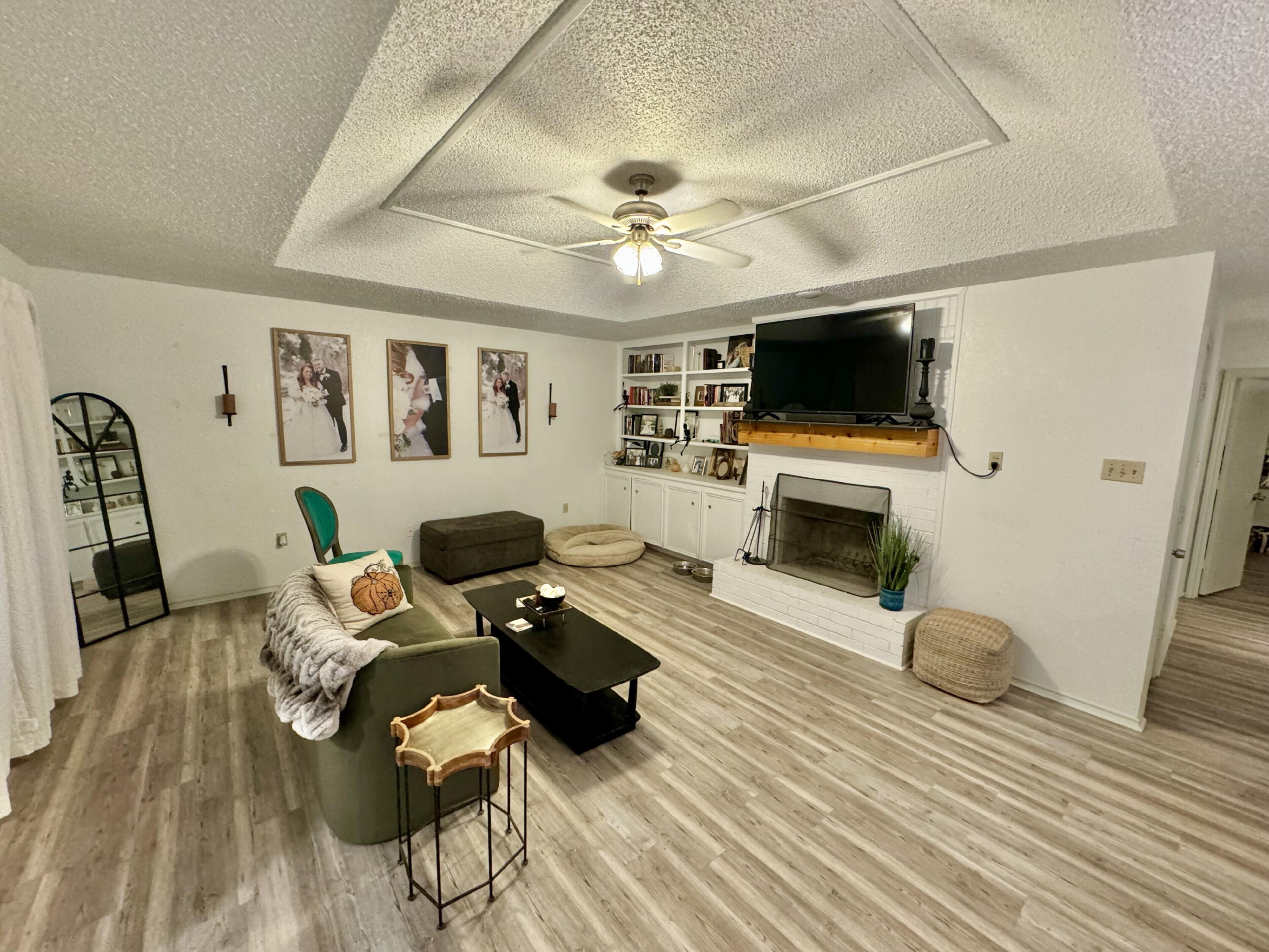 4804 76th Street, Unit A Lubbock, TX 79424 - Photo 3 of 31 a living room with furniture a flat screen tv and a fireplace