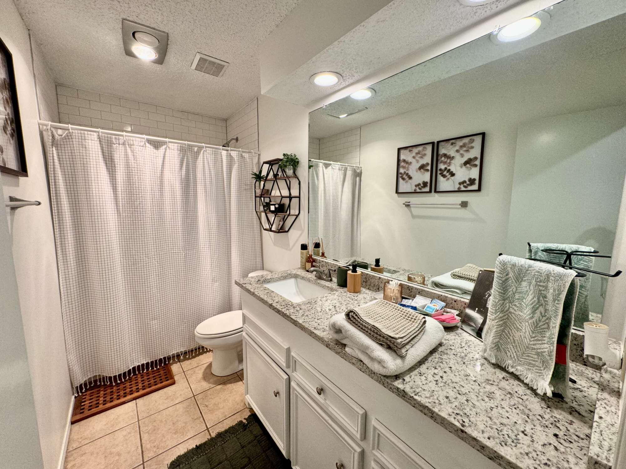 4804 76th Street, Unit A Lubbock, TX 79424 - Photo 31 of 31 a spacious bathroom with a granite countertop sink a toilet and a mirror