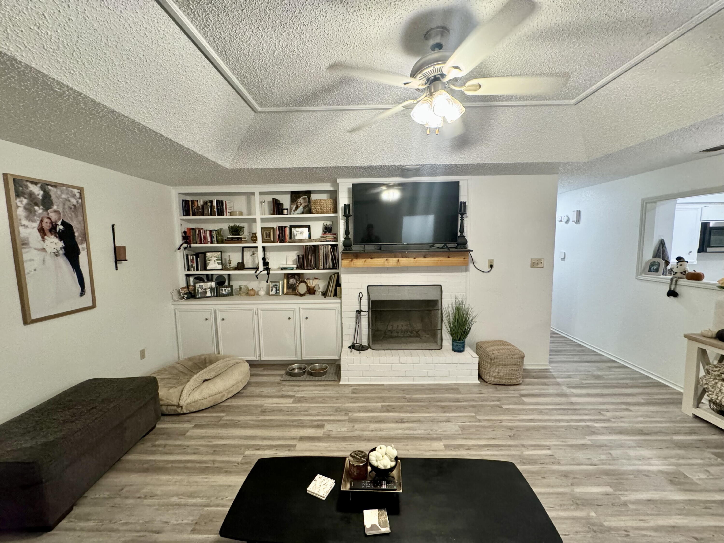 4804 76th Street, Unit A Lubbock, TX 79424 - Photo 4 of 31 a living room with furniture a flat screen tv and a fireplace