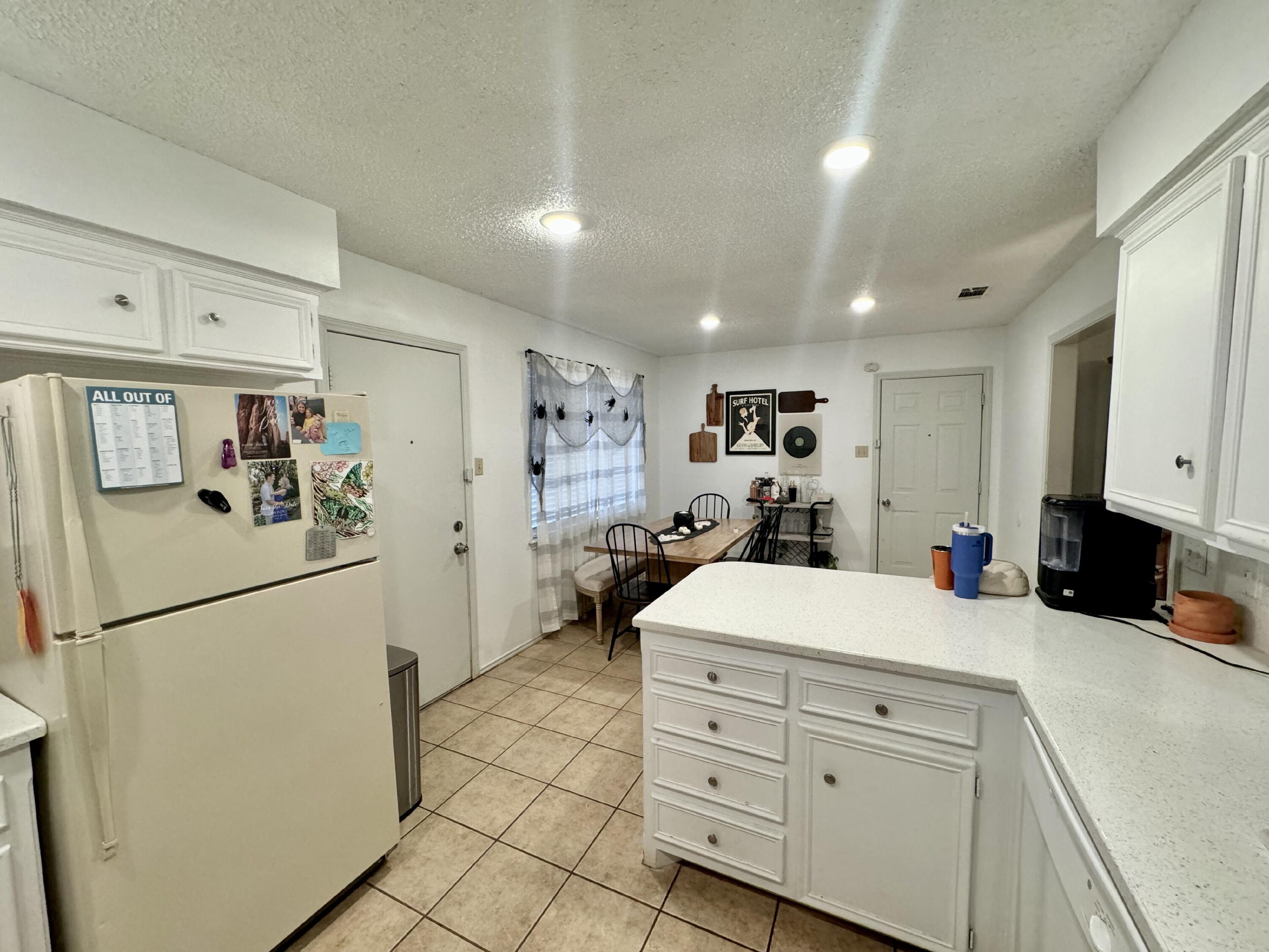 4804 76th Street, Unit A Lubbock, TX 79424 - Photo 7 of 31 a kitchen with white cabinets and refrigerator