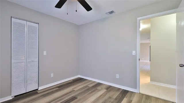 an empty room with a window and a fan