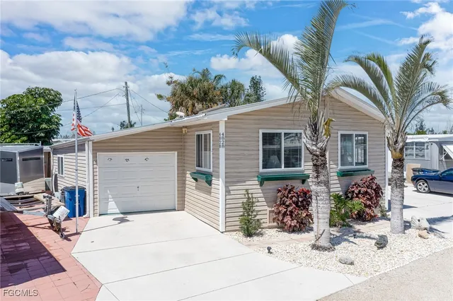 a front view of a house with a yard and potted plants