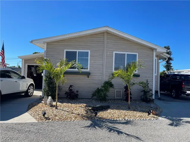 a house view with a sitting space fire pit and potted plants