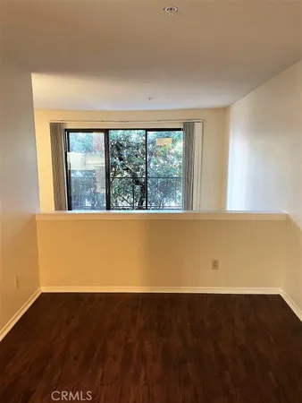 view of an empty room with wooden floor and a window