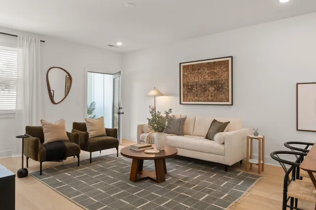 a living room with furniture a rug a lamp and a window