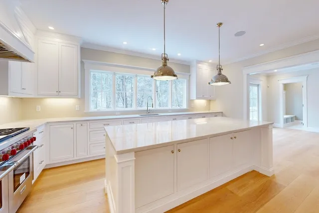a kitchen with kitchen island a stove a sink a center island and cabinets