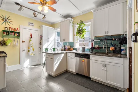 a kitchen with stainless steel appliances a white cabinets and window