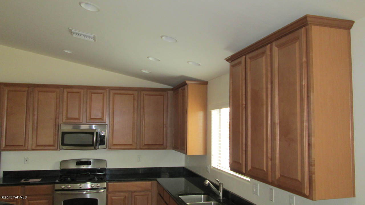 10855 East New Rock Ridge Drive Vail, AZ 85641 - Photo 15 of 34 a kitchen with wooden cabinets and a stove top oven