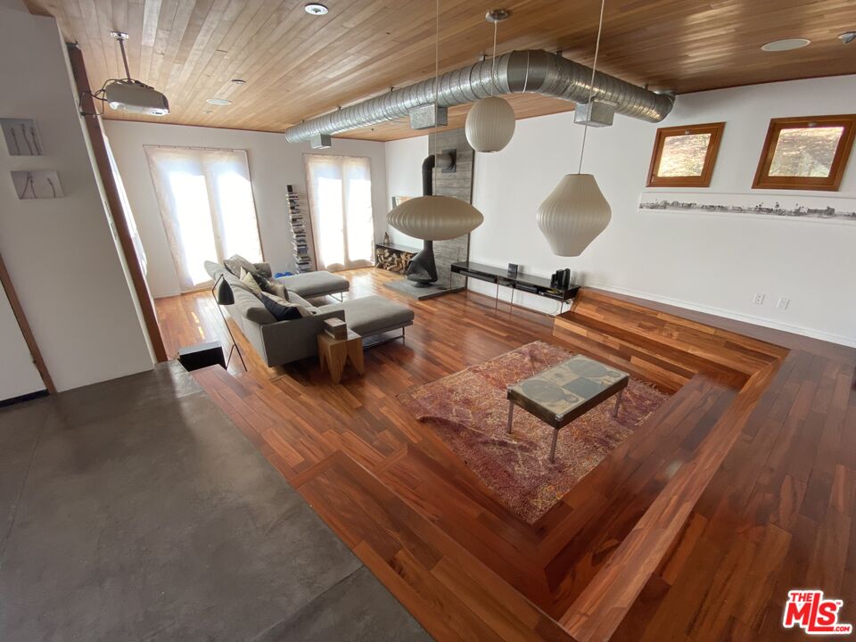 a living room with a gaming machine and wooden floor