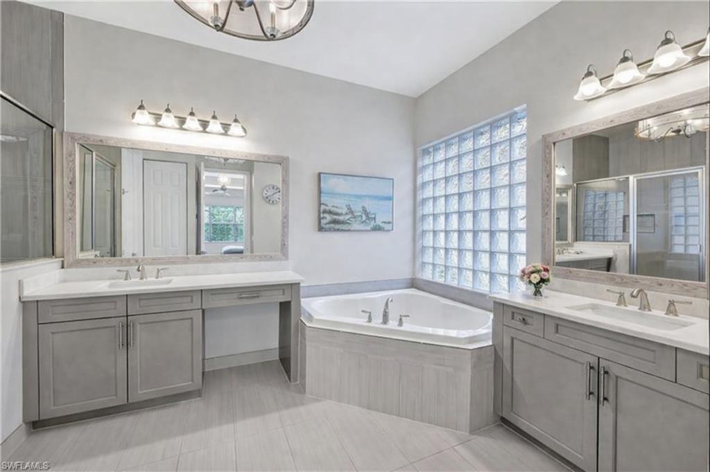 3407 Baltic Drive Naples, FL 34119 - Photo 15 of 31 a bathroom with a double vanity sink mirror and bathtub