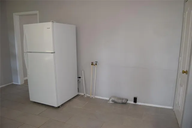 a view of an empty room with wooden floor and window