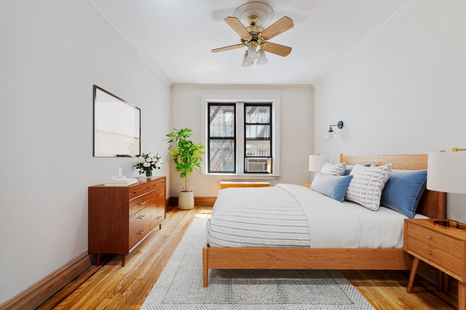 170 East 94th Street, Unit 5E Manhattan, NY 10128 - Photo 3 of 8 a bedroom with a large bed and a chandelier