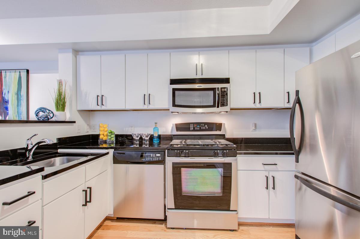 915 E Street Northwest, Unit 101 Washington, DC 20004 - Photo 13 of 34 a kitchen with cabinets stainless steel appliances and a counter space