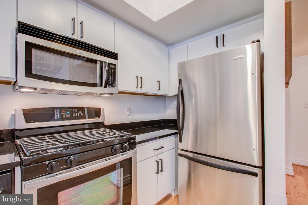 915 E Street Northwest, Unit 101 Washington, DC 20004 - Photo 14 of 34 a kitchen with stainless steel appliances a refrigerator stove and microwave