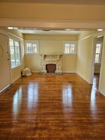 a view of empty room with wooden floor and fireplace