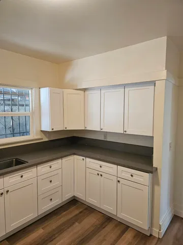 a kitchen with granite countertop white cabinets and white appliances