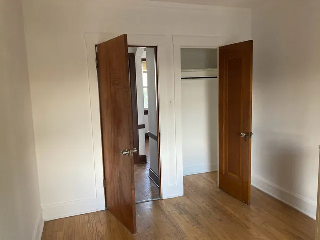 an empty room with wooden floor and closet