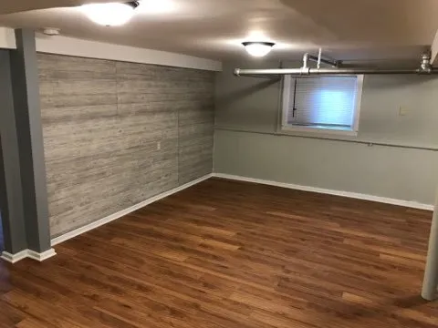 a view of an empty room with wooden floor