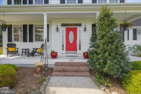 a kitchen with stainless steel appliances granite countertop a stove top oven a sink dishwasher and white cabinets with wooden floor