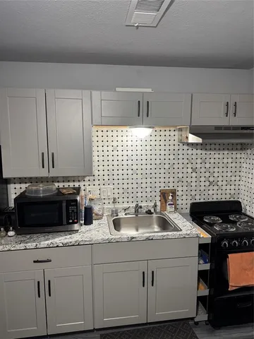 a kitchen with a sink stove and cabinets