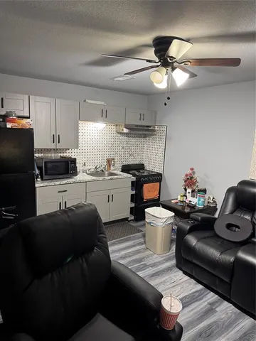 a living room with furniture and kitchen view