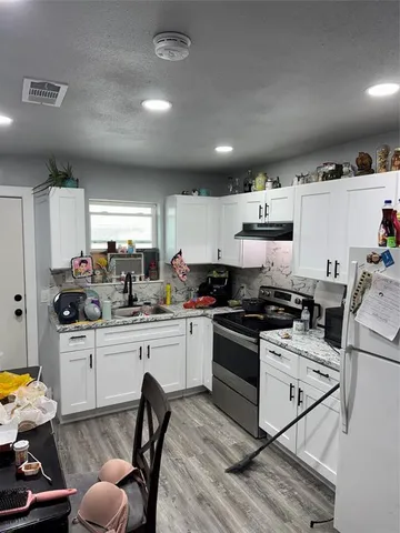 a kitchen with granite countertop a sink appliances cabinets and furniture