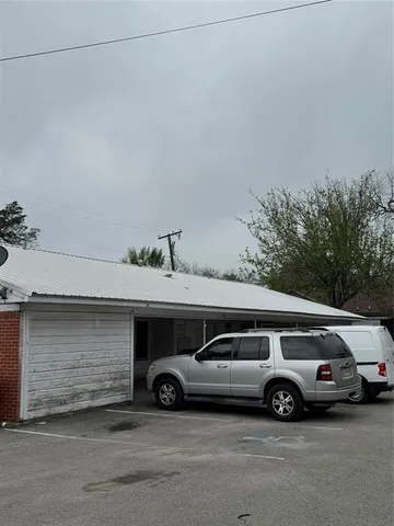 a view of a yard in front of a house with large tree