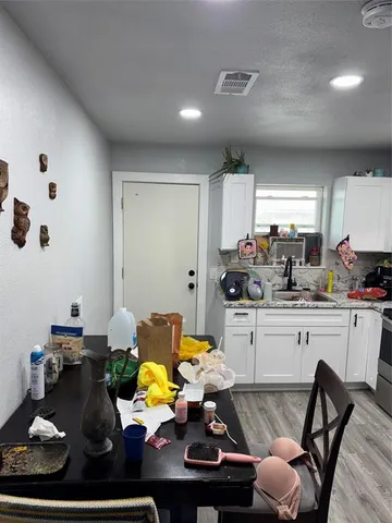 a kitchen with white cabinets and appliances