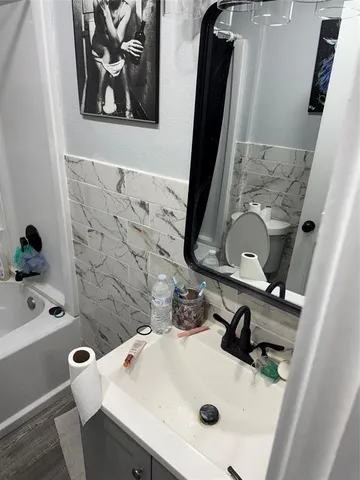 a bathroom with a sink and mirror with toilet
