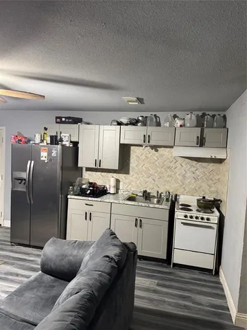 a kitchen with stainless steel appliances granite countertop a refrigerator a stove and a sink