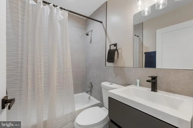 a bathroom with a sink a toilet and shower curtain