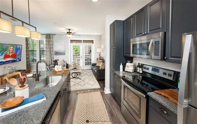 a kitchen with granite countertop lots of counter top space a sink stainless steel appliances and cabinets