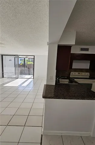 a view of a livingroom with wooden floor and a refrigerator