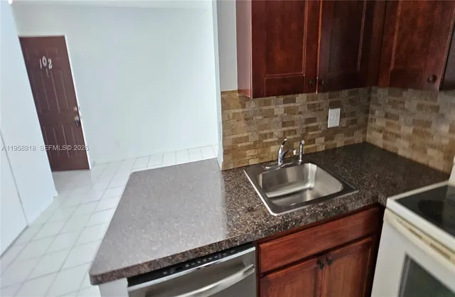 a kitchen with granite countertop a sink stove and cabinets