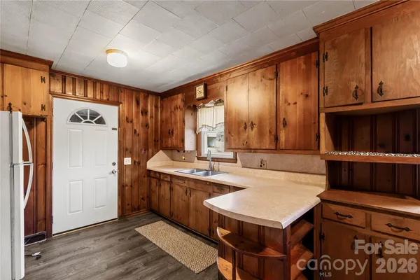 a kitchen with stainless steel appliances granite countertop a refrigerator a stove and a sink with wooden floors