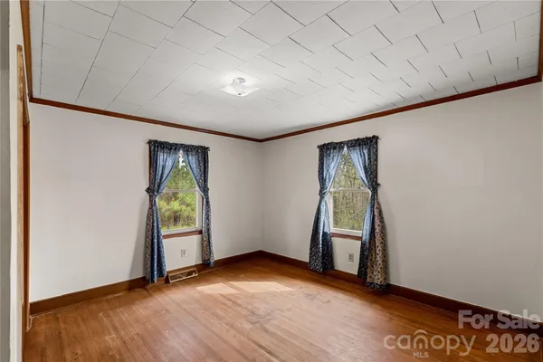 an empty room with wooden floor and a window