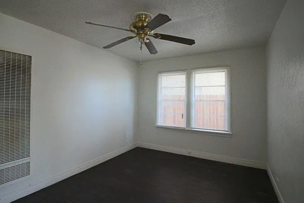 an empty room with a window and a ceiling fan